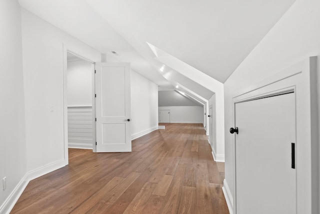 bonus room featuring vaulted ceiling with skylight and hardwood / wood-style floors