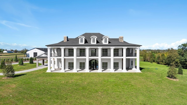 rear view of house with a lawn, french doors, and a balcony