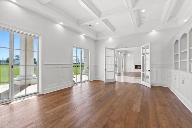 unfurnished living room with beamed ceiling, dark hardwood / wood-style floors, coffered ceiling, and built in shelves