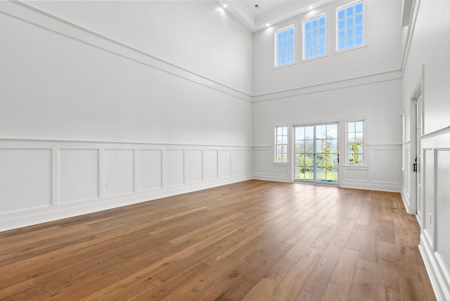 unfurnished living room featuring a high ceiling and wood-type flooring