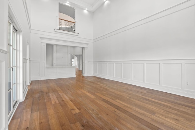 unfurnished living room with hardwood / wood-style floors and a high ceiling