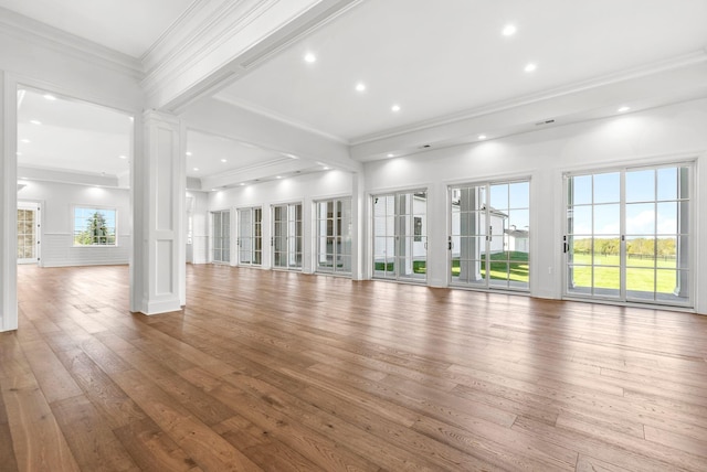 unfurnished living room featuring crown molding, wood-type flooring, and ornate columns