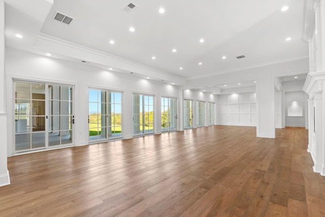 unfurnished living room featuring crown molding and hardwood / wood-style floors