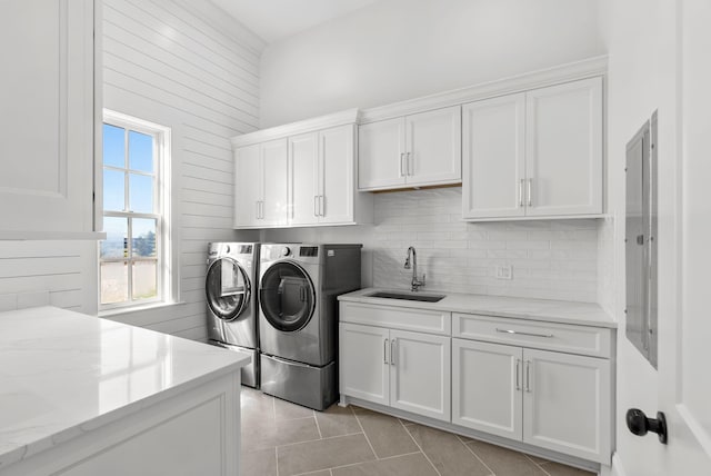 washroom featuring cabinets, washing machine and dryer, sink, and light tile patterned floors