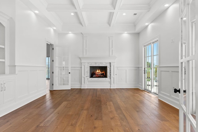 unfurnished living room with coffered ceiling, beam ceiling, french doors, and hardwood / wood-style flooring