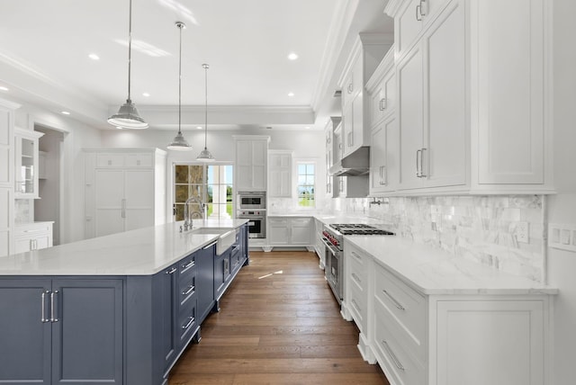 kitchen with pendant lighting, blue cabinets, white cabinetry, stainless steel range, and a spacious island