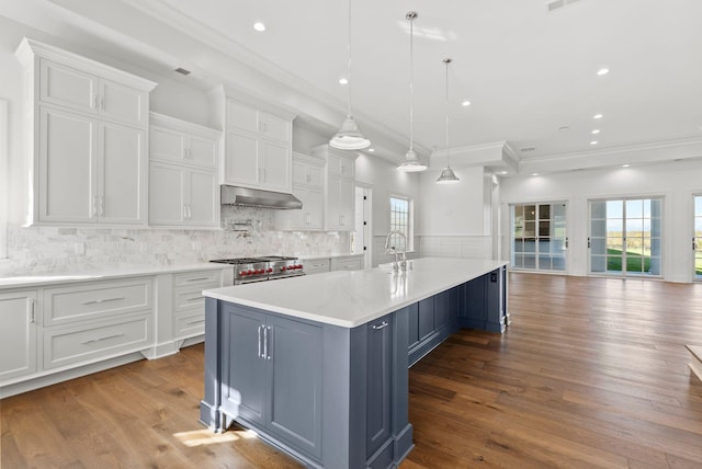 kitchen featuring a spacious island, white cabinetry, a kitchen bar, and decorative light fixtures