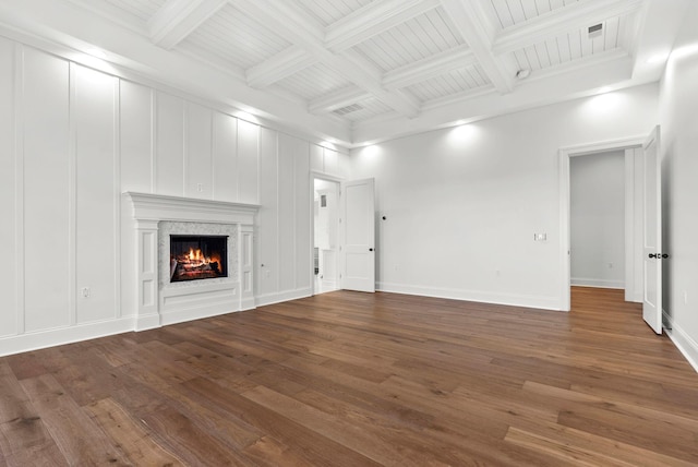 unfurnished living room with beamed ceiling, a fireplace, wood-type flooring, and coffered ceiling