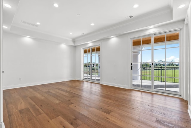 unfurnished room featuring hardwood / wood-style floors and a tray ceiling