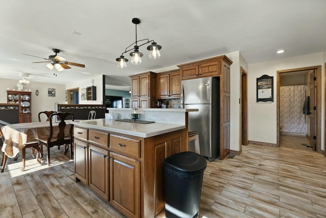 kitchen featuring pendant lighting, stainless steel fridge, a center island, and ceiling fan