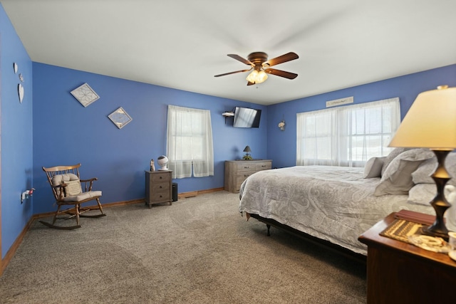 carpeted bedroom featuring multiple windows and ceiling fan