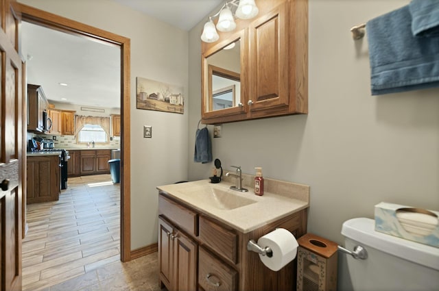 bathroom with vanity, decorative backsplash, and toilet