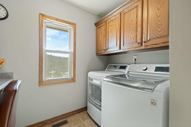 washroom featuring cabinets, separate washer and dryer, and light tile patterned floors