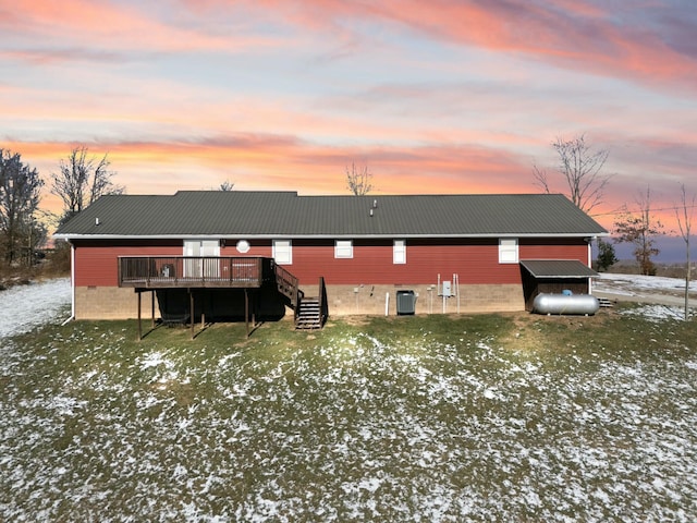 snow covered rear of property with central AC unit and a deck