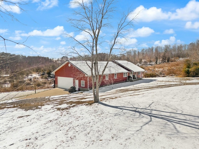 view of snowy exterior featuring a garage