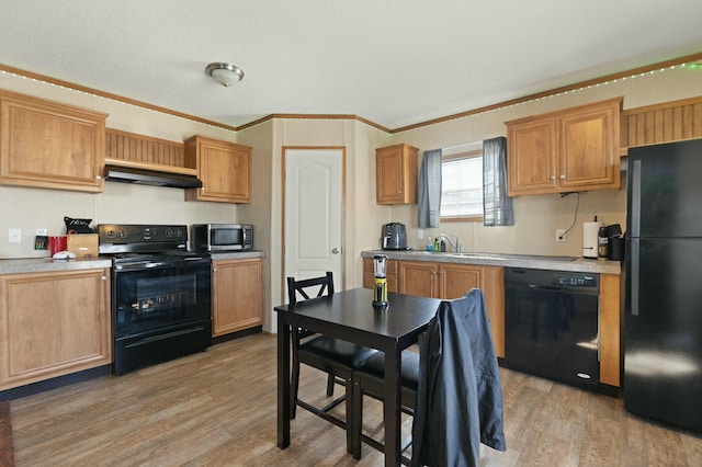 kitchen with crown molding, sink, light wood-type flooring, and black appliances