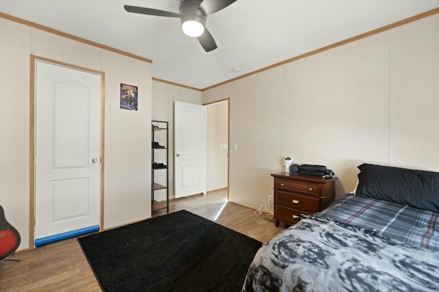 bedroom with crown molding, ceiling fan, and light hardwood / wood-style floors