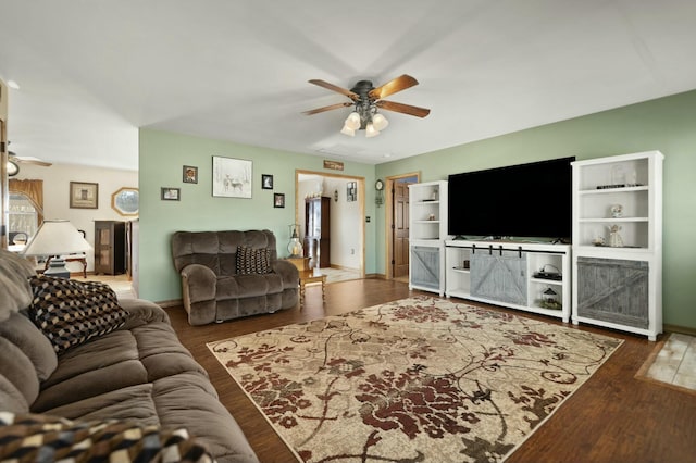 living room featuring ceiling fan and dark hardwood / wood-style floors