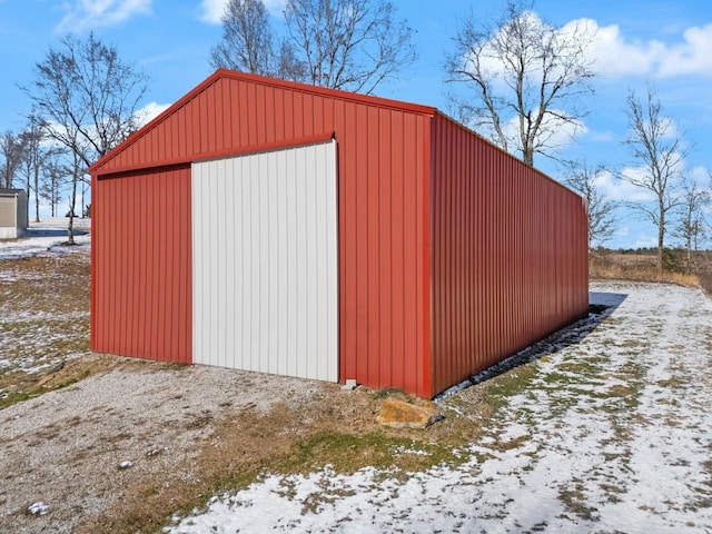 snow covered structure with a garage