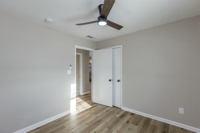 unfurnished bedroom with light hardwood / wood-style flooring, a closet, and ceiling fan