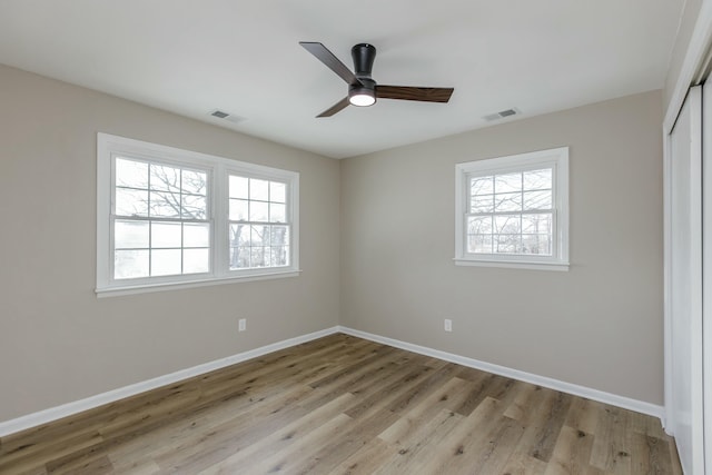 empty room with ceiling fan and light hardwood / wood-style flooring