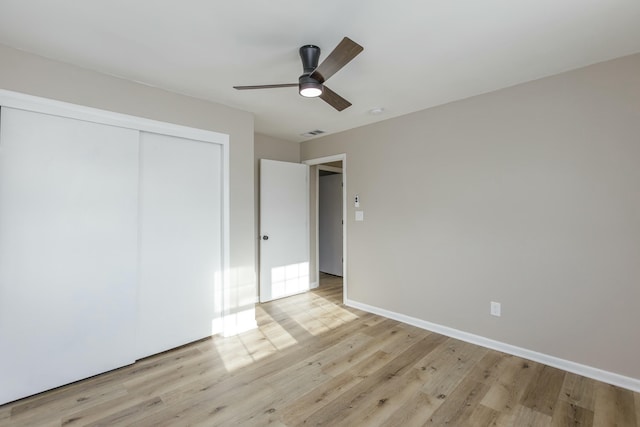 unfurnished bedroom with ceiling fan, a closet, and light wood-type flooring