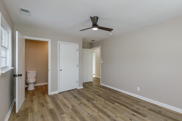 unfurnished bedroom with a closet, connected bathroom, ceiling fan, and light hardwood / wood-style floors