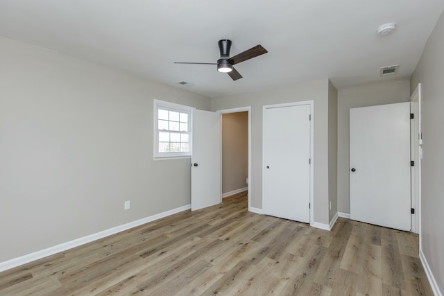 unfurnished bedroom featuring ceiling fan, a closet, and light wood-type flooring