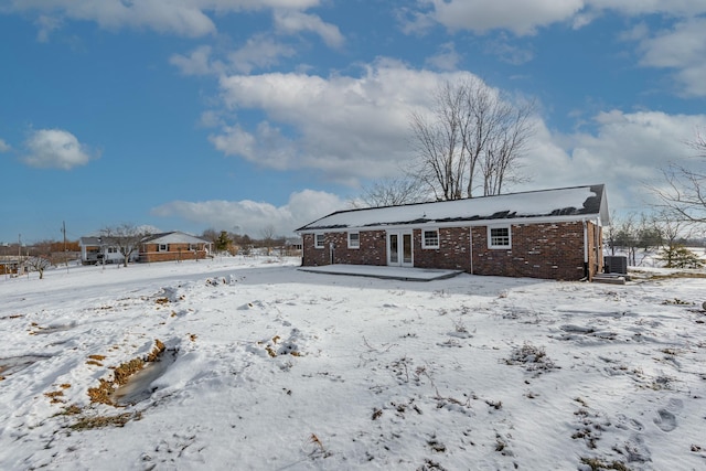 snow covered house featuring cooling unit