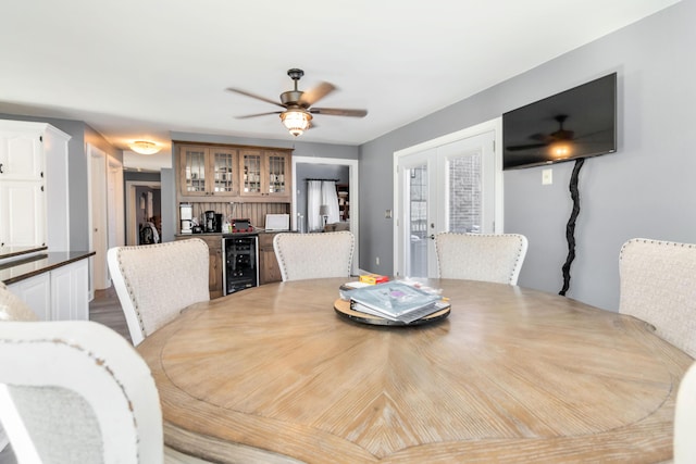 dining space with beverage cooler, ceiling fan, and french doors