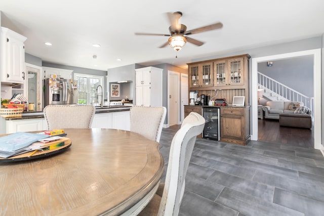 dining space with wine cooler, wet bar, and ceiling fan