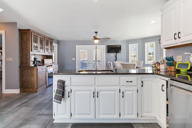 kitchen featuring dark stone countertops, white cabinets, stainless steel dishwasher, ceiling fan, and kitchen peninsula