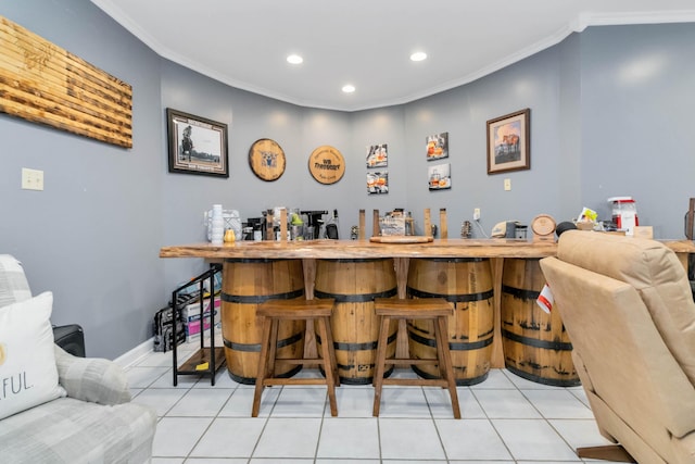 bar featuring crown molding and light tile patterned floors