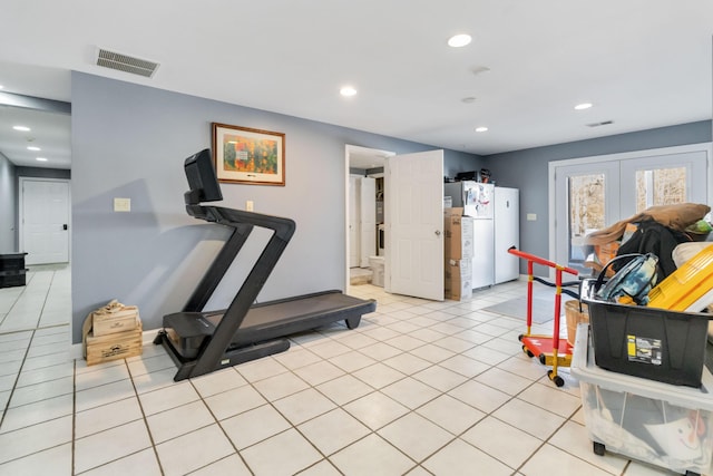 exercise area featuring light tile patterned floors and french doors