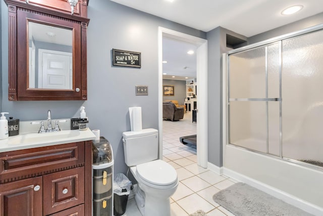 full bathroom with toilet, vanity, bath / shower combo with glass door, and tile patterned flooring