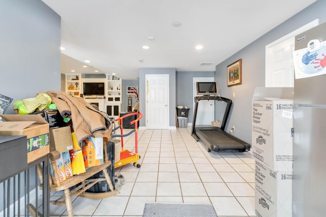 exercise area featuring light tile patterned flooring