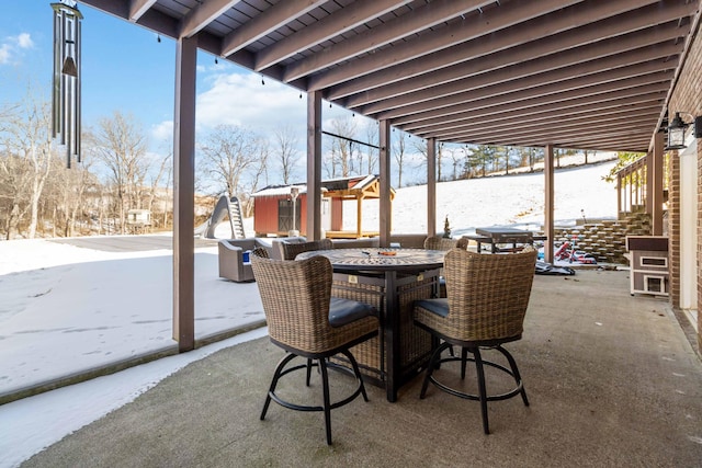 snow covered patio featuring an outbuilding