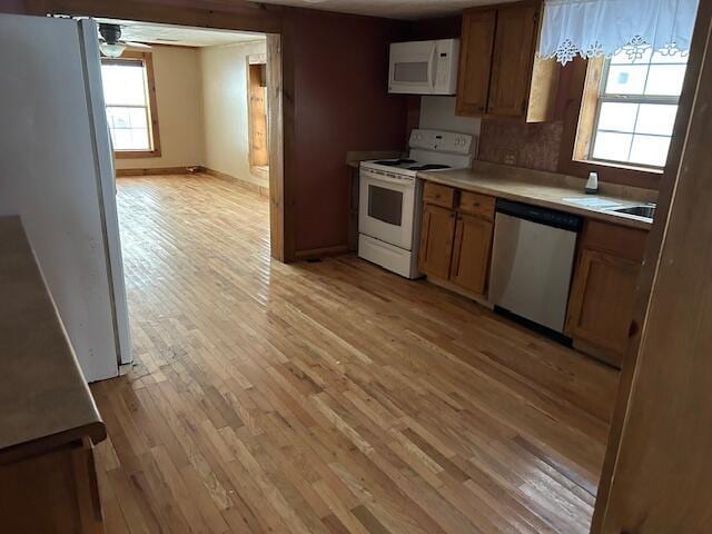 kitchen featuring ceiling fan, white appliances, and light hardwood / wood-style floors