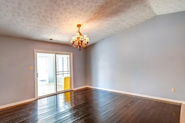 unfurnished room featuring a chandelier, hardwood / wood-style floors, and a textured ceiling