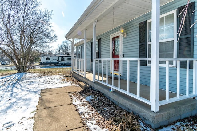 snow covered property featuring covered porch