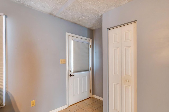 interior space featuring light tile patterned floors and a textured ceiling