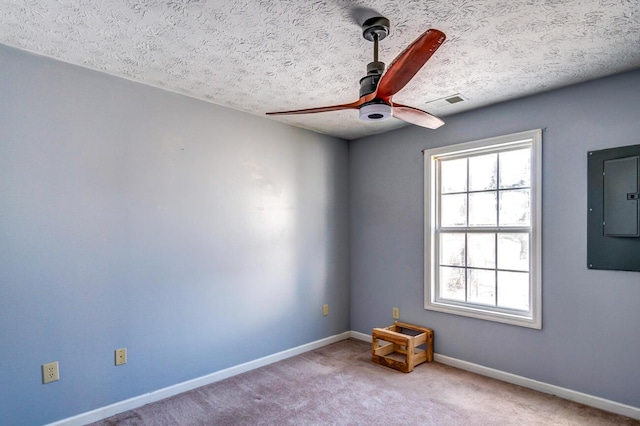 unfurnished room with ceiling fan, light colored carpet, electric panel, and a textured ceiling