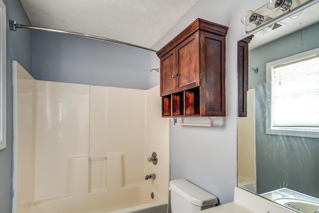 full bathroom with shower / bath combination, vanity, a textured ceiling, and toilet