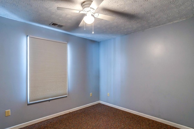 carpeted spare room with a textured ceiling and ceiling fan