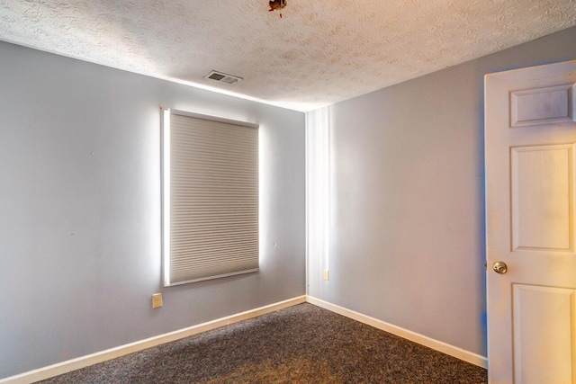 carpeted empty room with a textured ceiling