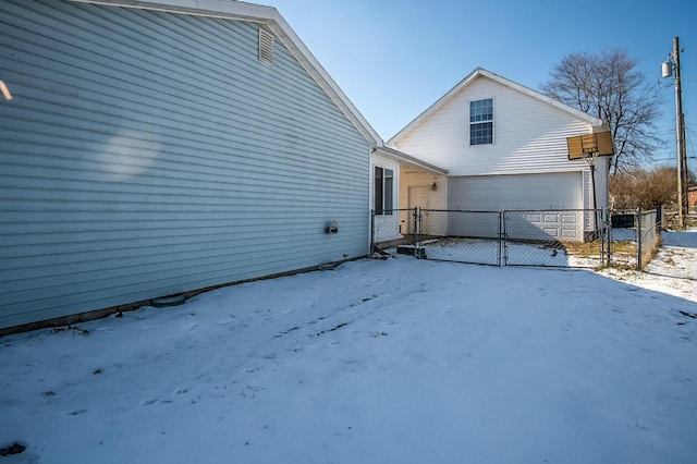 view of snow covered exterior with a garage