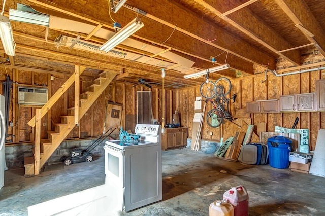 basement featuring a wall mounted air conditioner and washer / dryer