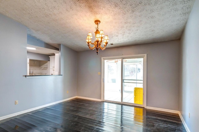 spare room featuring vaulted ceiling, a chandelier, a textured ceiling, and dark hardwood / wood-style flooring