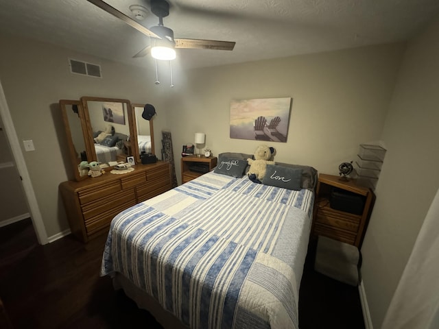 bedroom with dark hardwood / wood-style flooring and ceiling fan