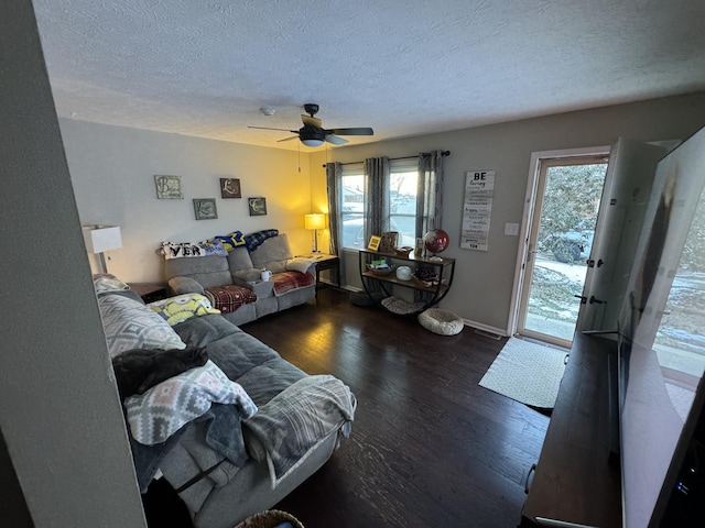 living room featuring ceiling fan, dark hardwood / wood-style flooring, and a textured ceiling